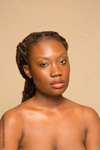 Studio portrait of shirtless woman with braided hair