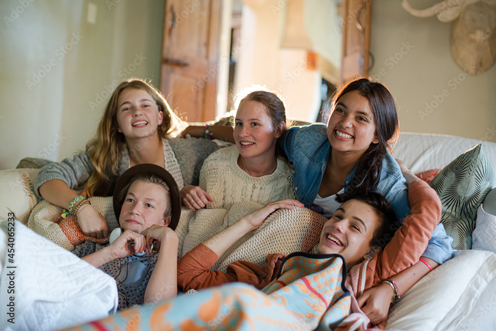 Group of teenagers having fun while watching tv on sofa Group of teenagers having fun while watching tv on sofa