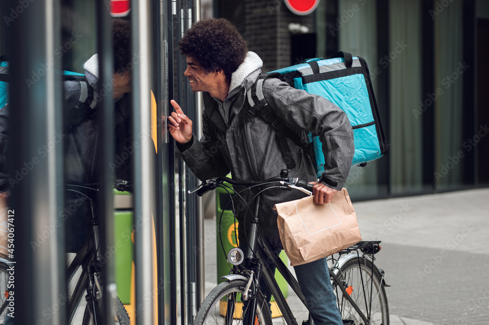 Male courier with bicycle delivering packages in city. Male courier with bicycle delivering packages in city.