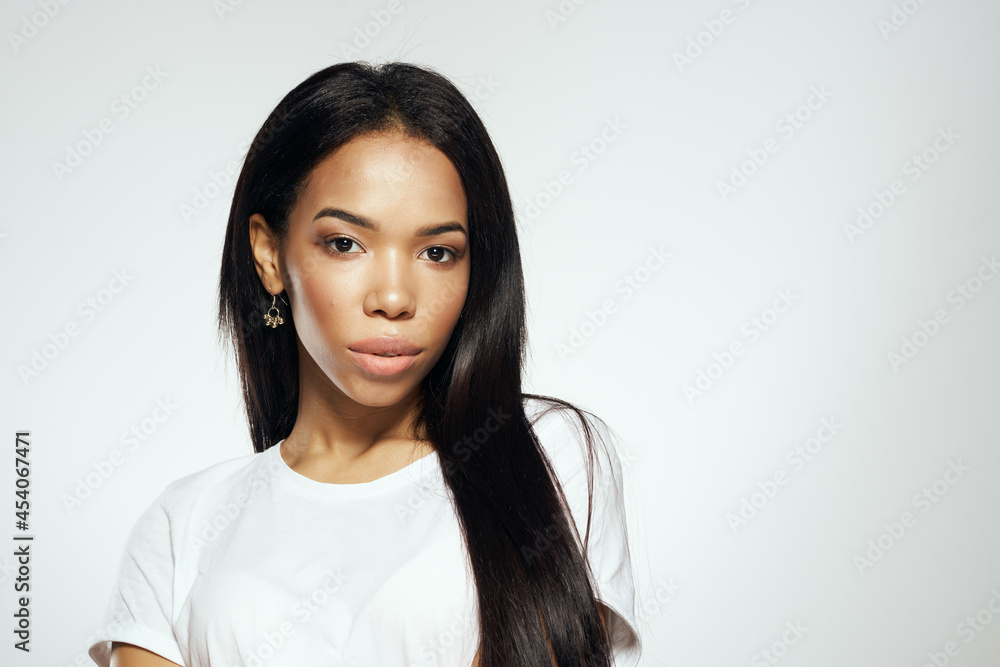 pretty woman of african appearance in t-shirt fashionable hairstyle light background pretty woman of african appearance in t-shirt fashionable hairstyle light background