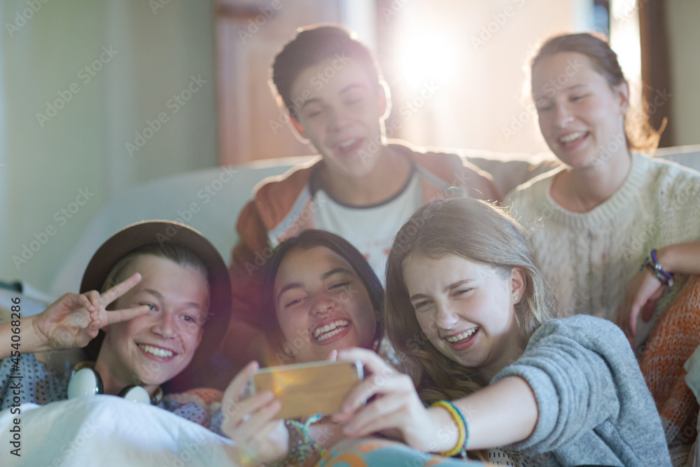 Group of teenagers taking selfie on sofa in living room Group of teenagers taking selfie on sofa in living room