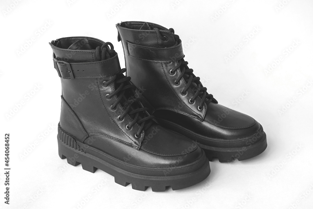 Women winter footwear on a white concrete background, modern style and elegant design of shoes Women winter footwear on a white concrete background, modern style and elegant design of shoes