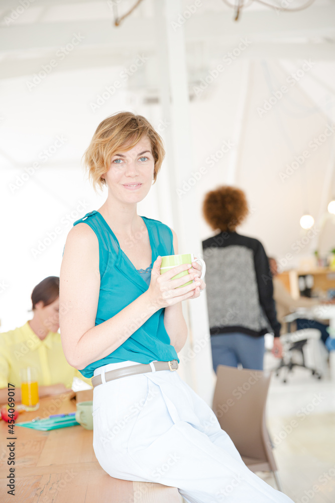 Young smiling woman sitting at desk Young smiling woman sitting at desk