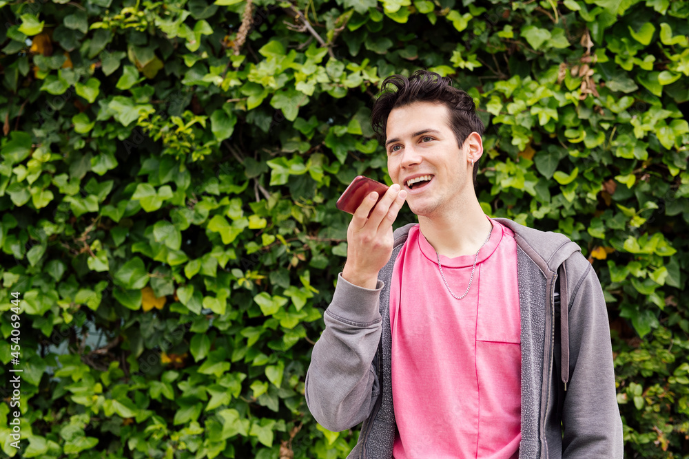 happy teen boy recording a voice message on phone happy teen boy recording a voice message on phone