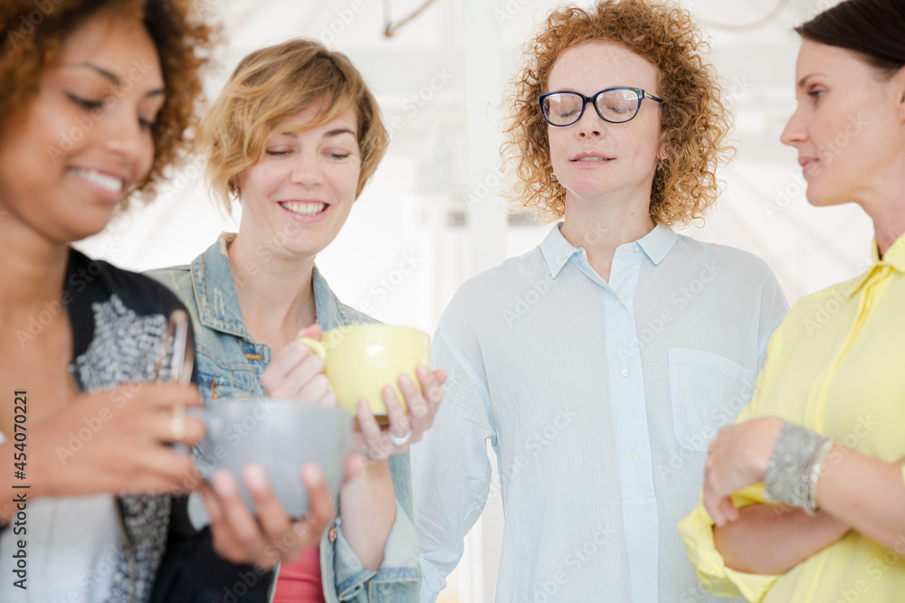 Women with coffe cup smiling in office Women with coffe cup smiling in office
