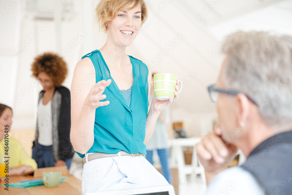 Man and woman sitting in office,smiling and talking Man and woman sitting in office,smiling and talking