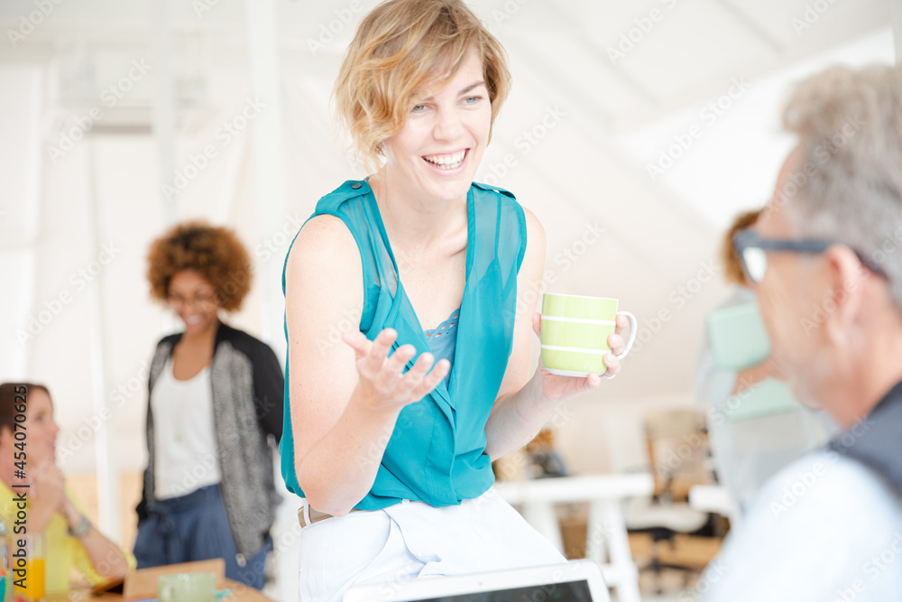 Fototapeta premium Man and woman sitting in office,smiling and talking