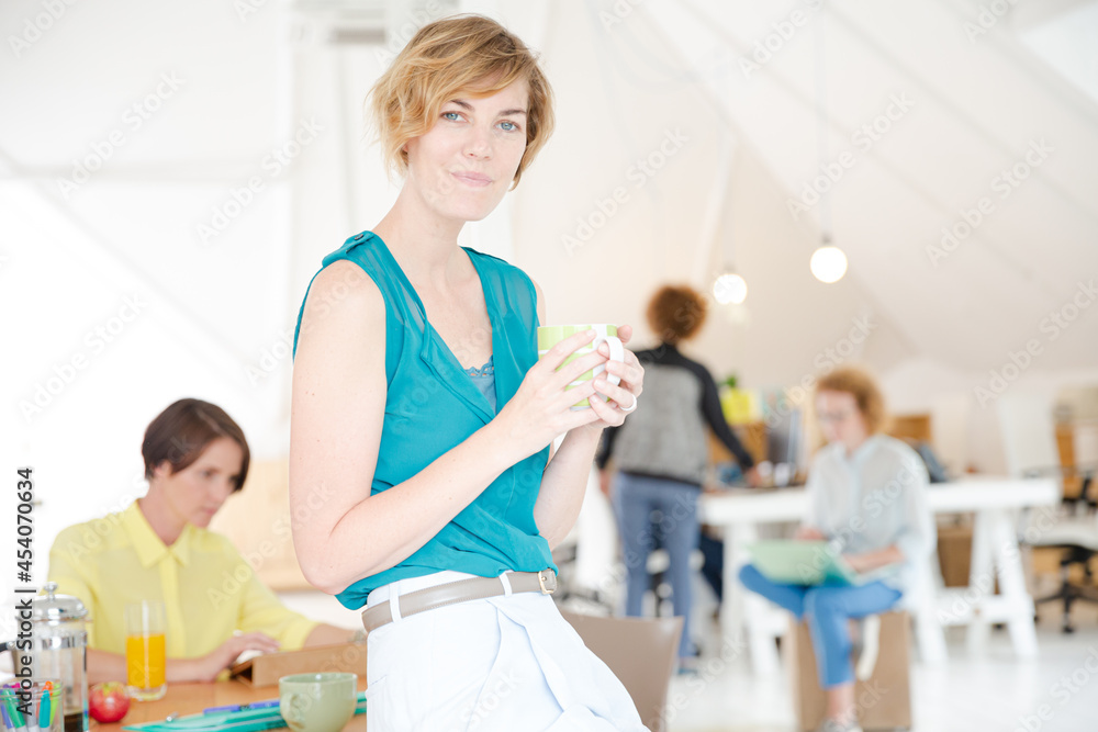 Obraz premium Young smiling woman sitting at desk