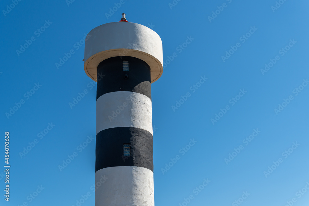 Close-up of the lighthouse of Colonia de Sant Jordi town on the island of Mallorca with the blue sky in the background