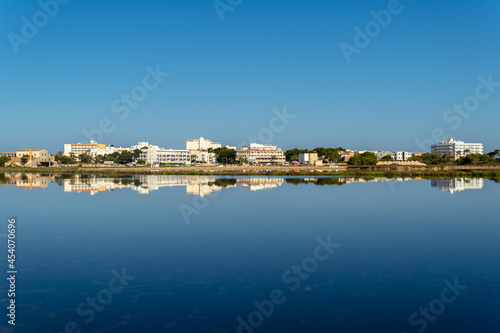 General view of the Mallorcan town of Colonia de Sant Jordi at sunrise reflected in the pond of the salt works photo