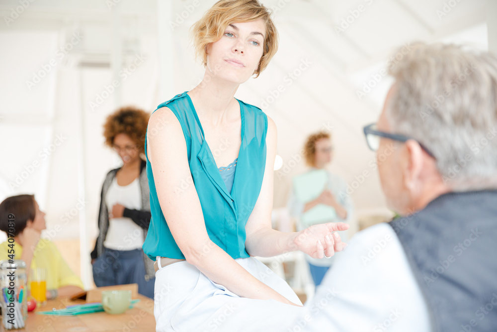 Obraz premium Man and woman sitting in office,smiling and talking