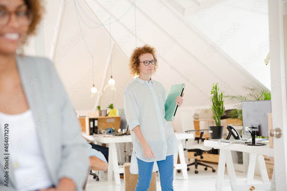 Fototapeta premium Woman walking and carrying laptop, joining colleague from office