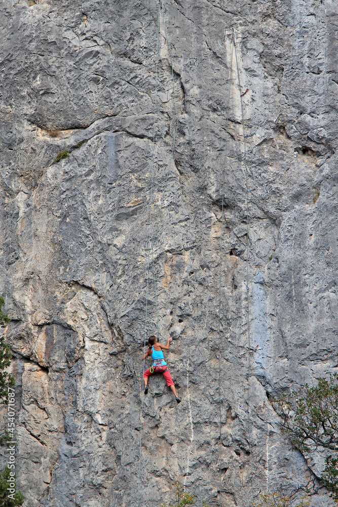 a brave climbing girl climbs a high rock