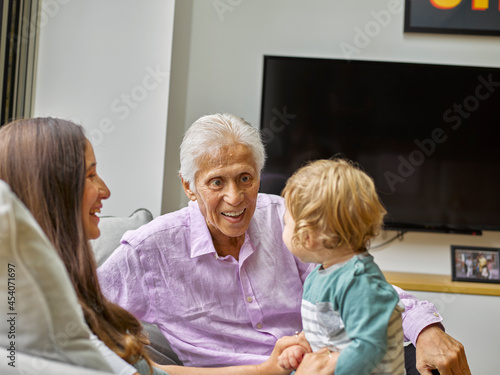 Mother and grandfather with baby boy in living room