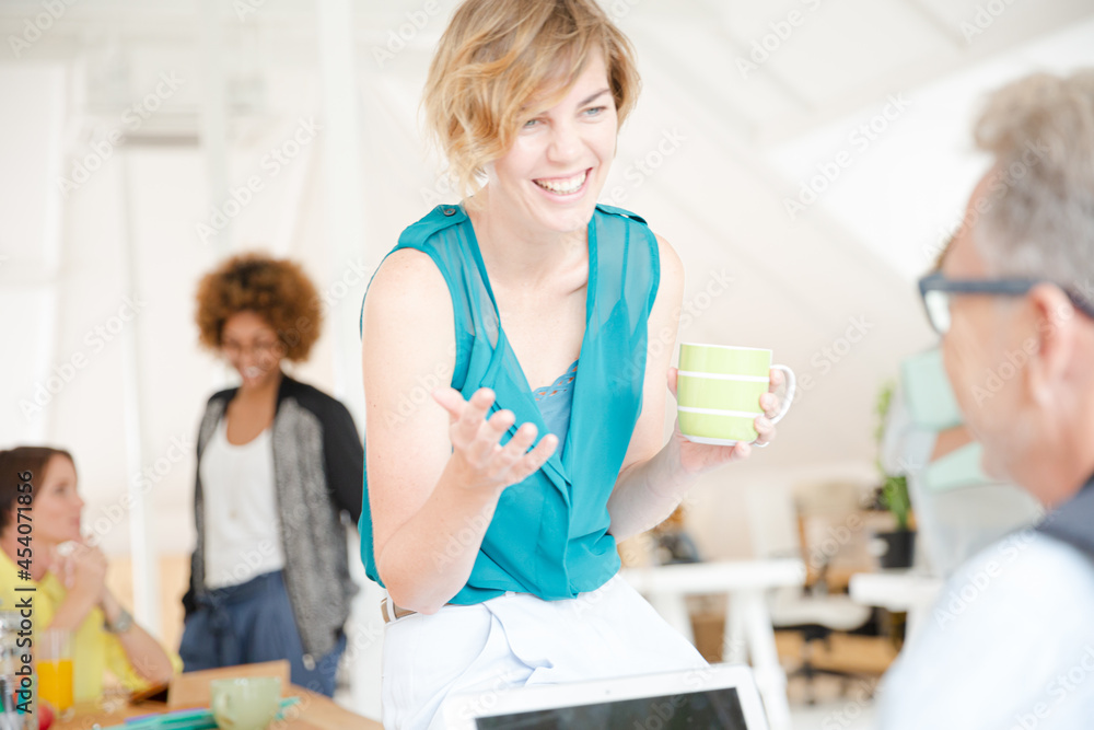 Man and woman sitting in office,smiling and talking Man and woman sitting in office,smiling and talking