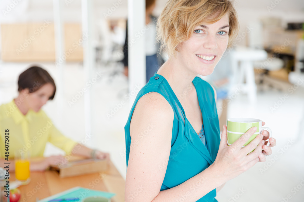 Young smiling woman sitting at desk Young smiling woman sitting at desk