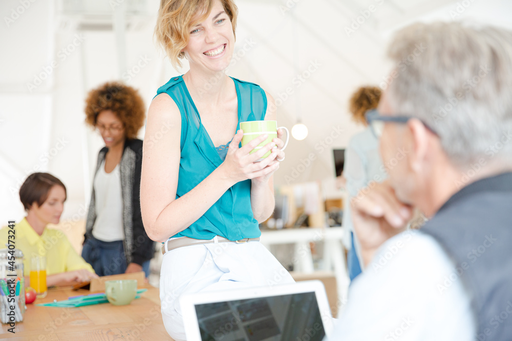 Man and woman sitting in office,smiling and talking Man and woman sitting in office,smiling and talking