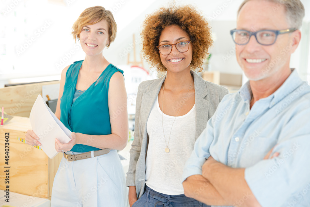 Obraz premium Colleagues smiling in office, holding documents
