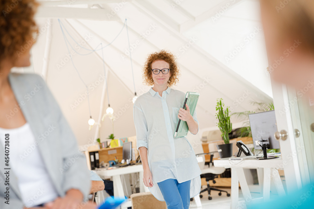Fototapeta premium Woman walking and carrying laptop, joining colleague from office