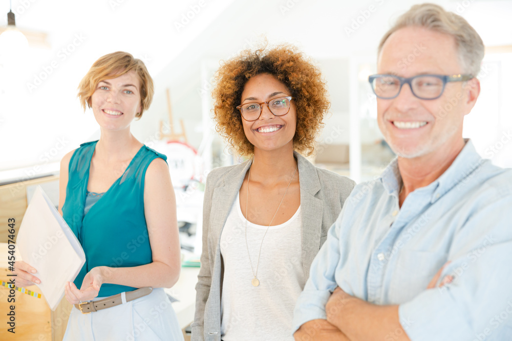 Obraz premium Colleagues smiling in office, holding documents