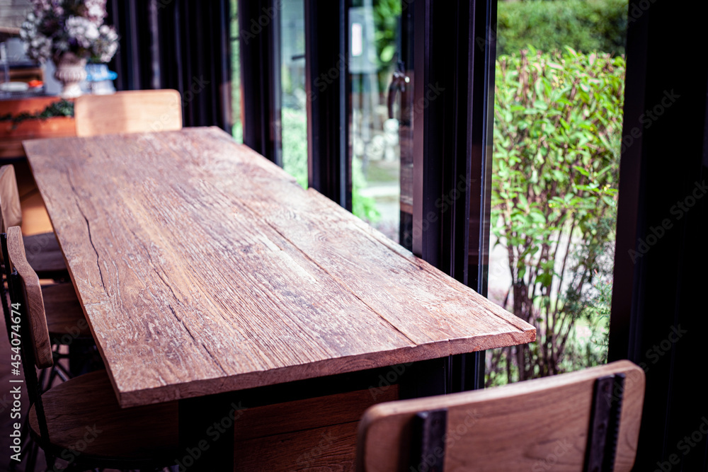 Empty dark wooden table and blur interior over blur in coffee shop Background.