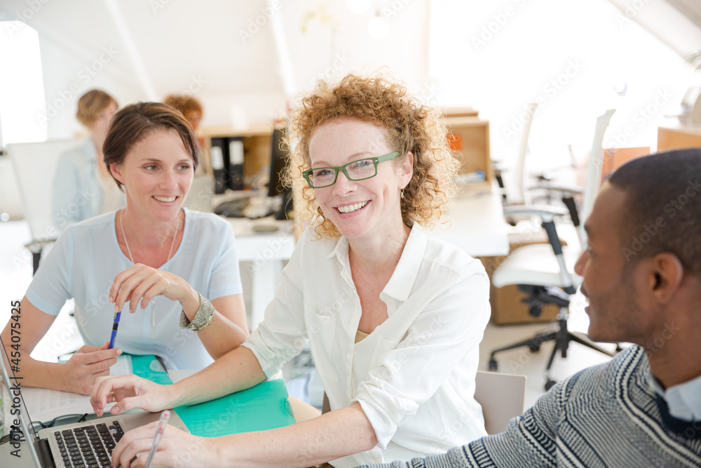 Obraz premium Office workers talking over laptop at desk