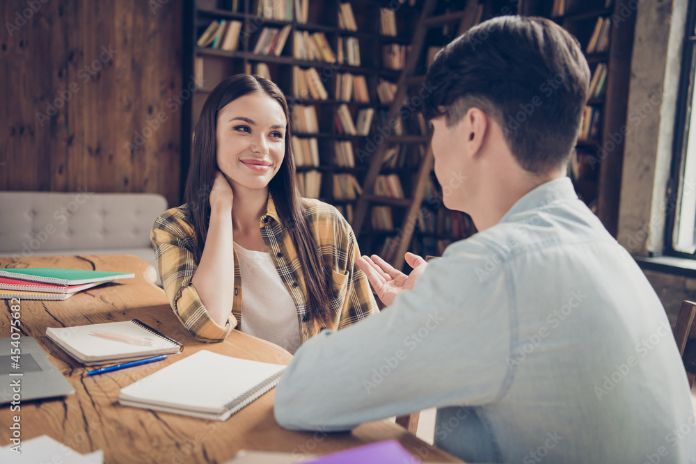 Portrait of two attractive cheerful learners communicating sharing experience at library loft industrial interior indoors Portrait of two attractive cheerful learners communicating sharing experience at library loft industrial interior indoors