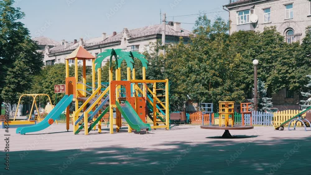 Rotation of an Empty Multicolored Carousel on a Playground in a City Park. Deserted park in summertime. People, children stay at home on self-isolation. Pandemic, quarantine, infection, covid-19. 4K. Rotation of an Empty Multicolored Carousel on a Playground in a City Park. Deserted park in summertime. People, children stay at home on self-isolation. Pandemic, quarantine, infection, covid-19. 4K.