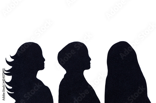 Black silhouettes of women, first one with long hear, second wears hijab covering her head and third wears burqua. Comparison of how cultural and religious aspects influence individuality of women. photo