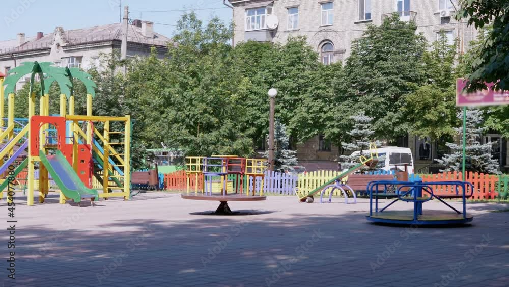 Rotation of an Empty Multicolored Carousel on a Playground in a City Park. Deserted park in summertime. People, children stay at home on self-isolation. Pandemic, quarantine, infection, covid-19. 4K. Rotation of an Empty Multicolored Carousel on a Playground in a City Park. Deserted park in summertime. People, children stay at home on self-isolation. Pandemic, quarantine, infection, covid-19. 4K.