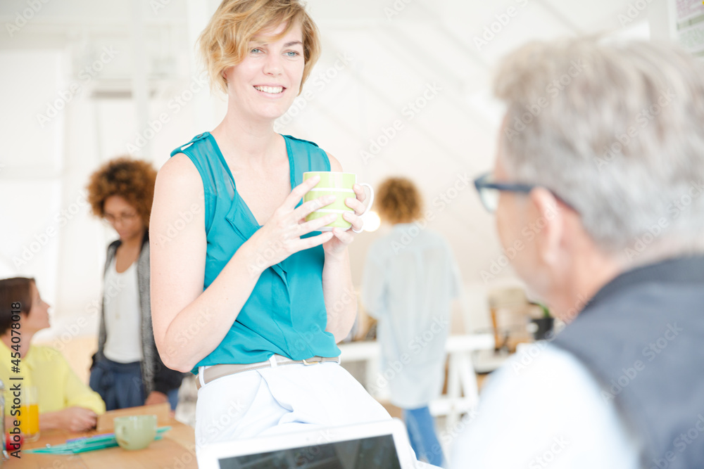 Man and woman sitting in office,smiling and talking