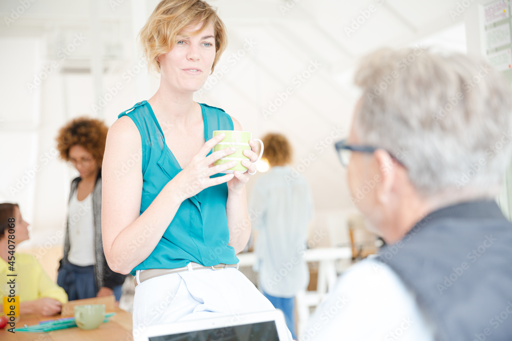 Man and woman sitting in office,smiling and talking Man and woman sitting in office,smiling and talking