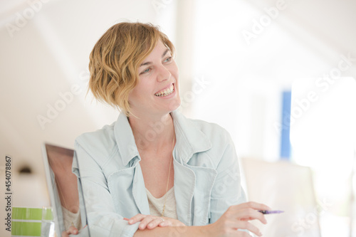 Portrait of woman sitting at desk with laptop in office