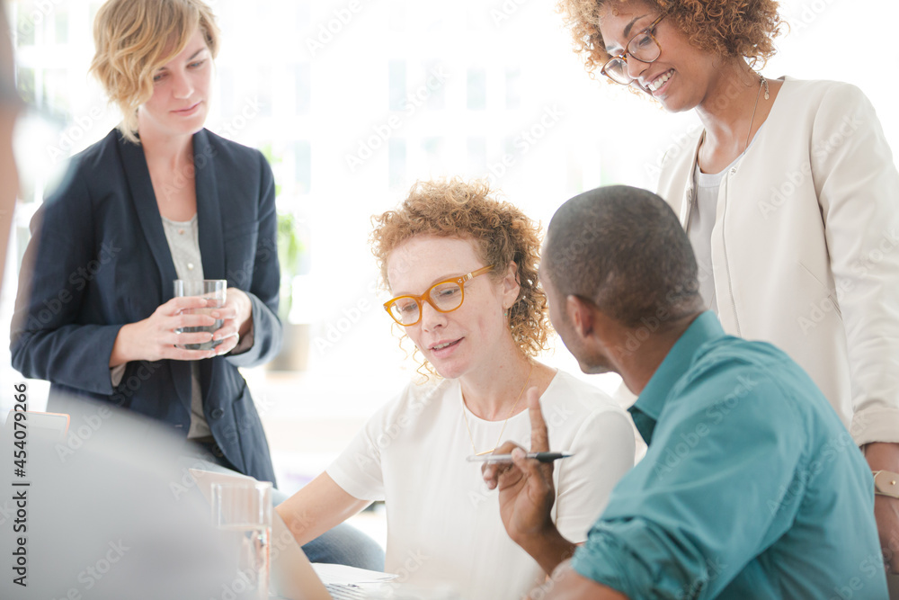 Office workers talking and smiling at meeting Office workers talking and smiling at meeting