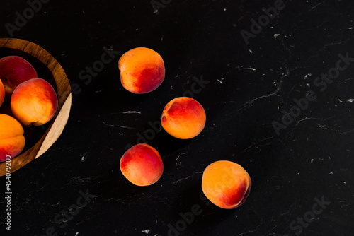 Close-up of fresh.Space for text top view. A group of ripe peaches on dark kitchen table.