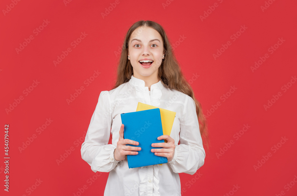 amazed child in white shirt ready to study do homework with book on red background, back to school amazed child in white shirt ready to study do homework with book on red background, back to school
