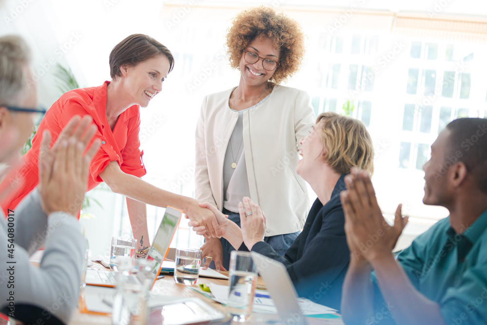Obraz premium Office workers shaking hands at desk