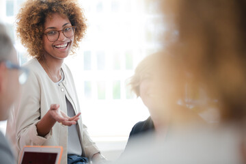 Office workers talking and smiling at meeting