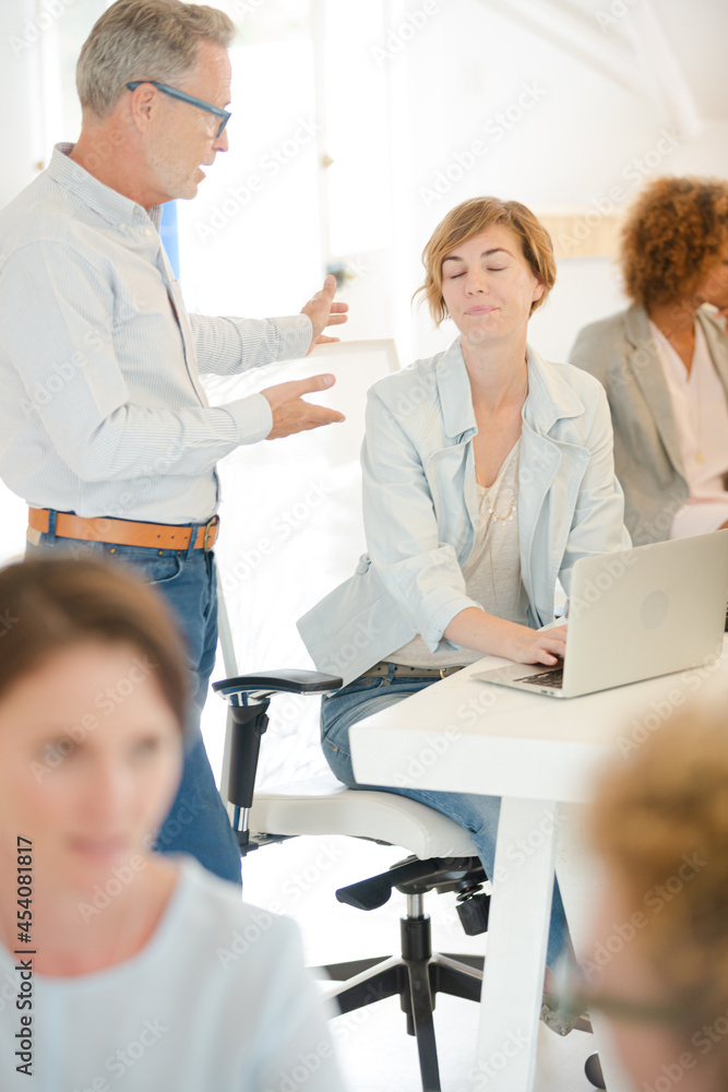 Office workers talking at desk Office workers talking at desk