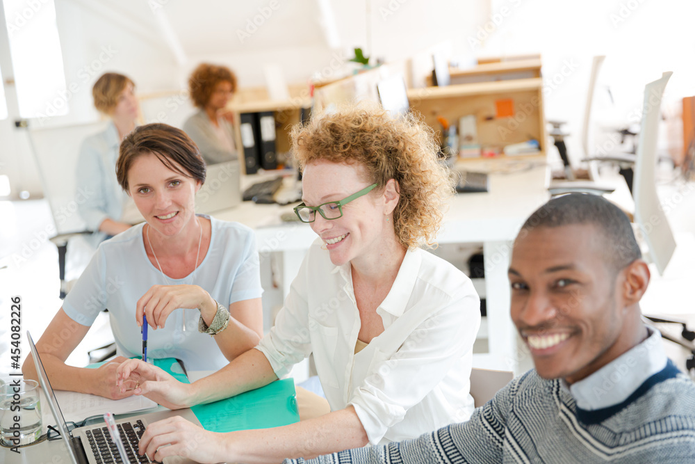 Obraz premium Office workers talking over laptop at desk