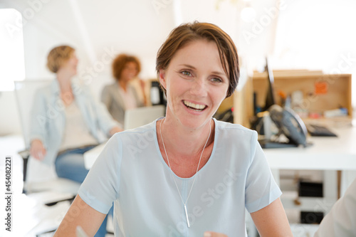 Portrait of woman sitting at desk in office and smiling