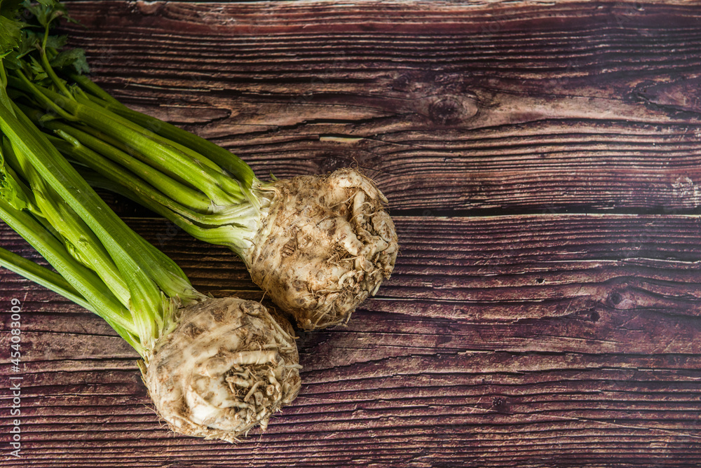 Tuber of celery with leaves, green bio vegetables from village gardening, farm fresh produce, organic food on wood Tuber of celery with leaves, green bio vegetables from village gardening, farm fresh produce, organic food on wood