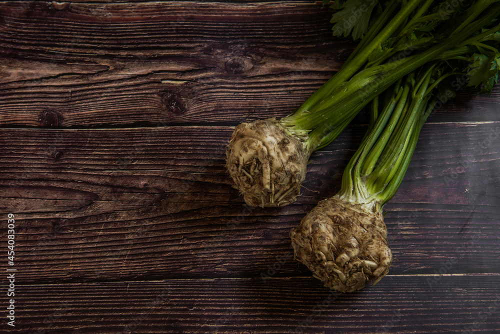 Tuber of celery with leaves, green bio vegetables from village gardening, farm fresh produce, organic food on wood Tuber of celery with leaves, green bio vegetables from village gardening, farm fresh produce, organic food on wood