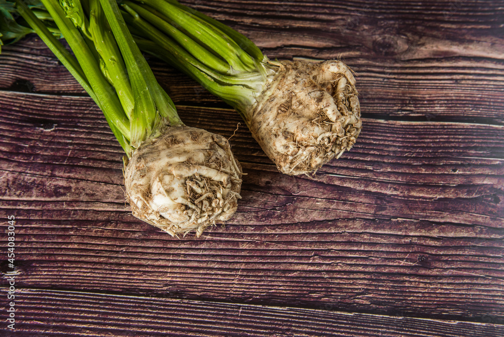 Tuber of celery with leaves, green bio vegetables from village gardening, farm fresh produce, organic food on wood Tuber of celery with leaves, green bio vegetables from village gardening, farm fresh produce, organic food on wood