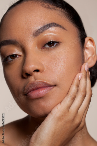 Portrait of young woman touching face photo