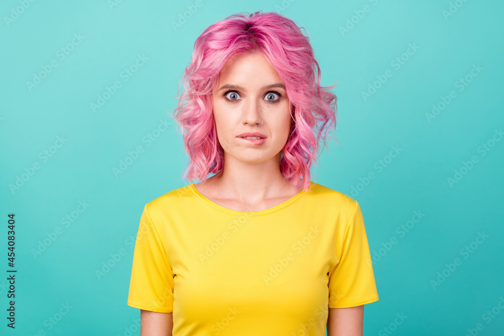 Photo of young nervous pink hairdo lady bite lip wear yellow t-shirt isolated on teal color background Photo of young nervous pink hairdo lady bite lip wear yellow t-shirt isolated on teal color background