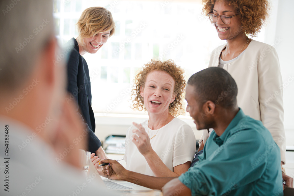 Office workers talking and smiling at meeting Office workers talking and smiling at meeting