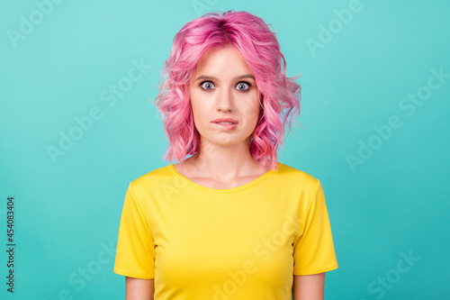 Photo of young nervous pink hairdo lady bite lip wear yellow t-shirt isolated on teal color background
