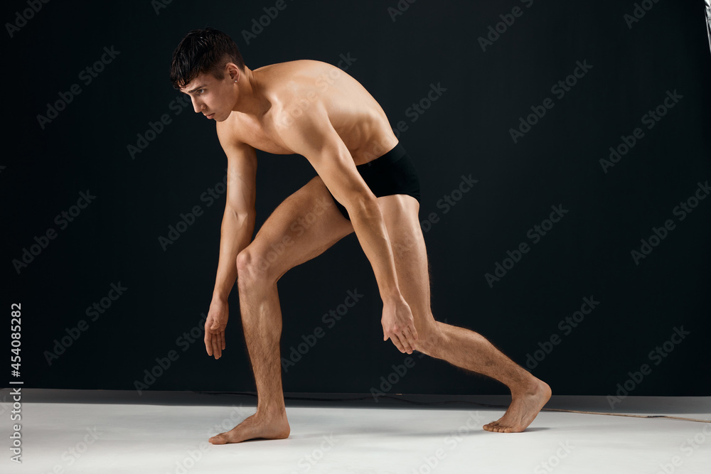 sporty man with pumped up muscular body black panties posing dark studio background
