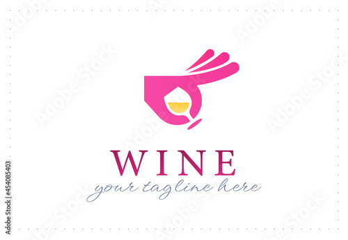 Elegant logo emblem design template with glass of yellow wine and hand gesturing OK on white background